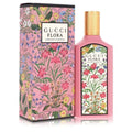 Gucci Flora Eau de Parfum bottle and its matching outer packaging box, both decorated with a vibrant pink, green, and multicolor floral pattern, on a white background.
