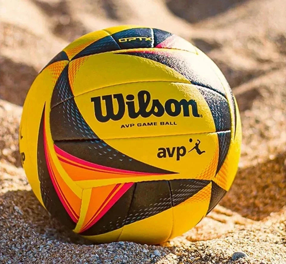 Yellow and black Wilson volleyball on a sandy background
